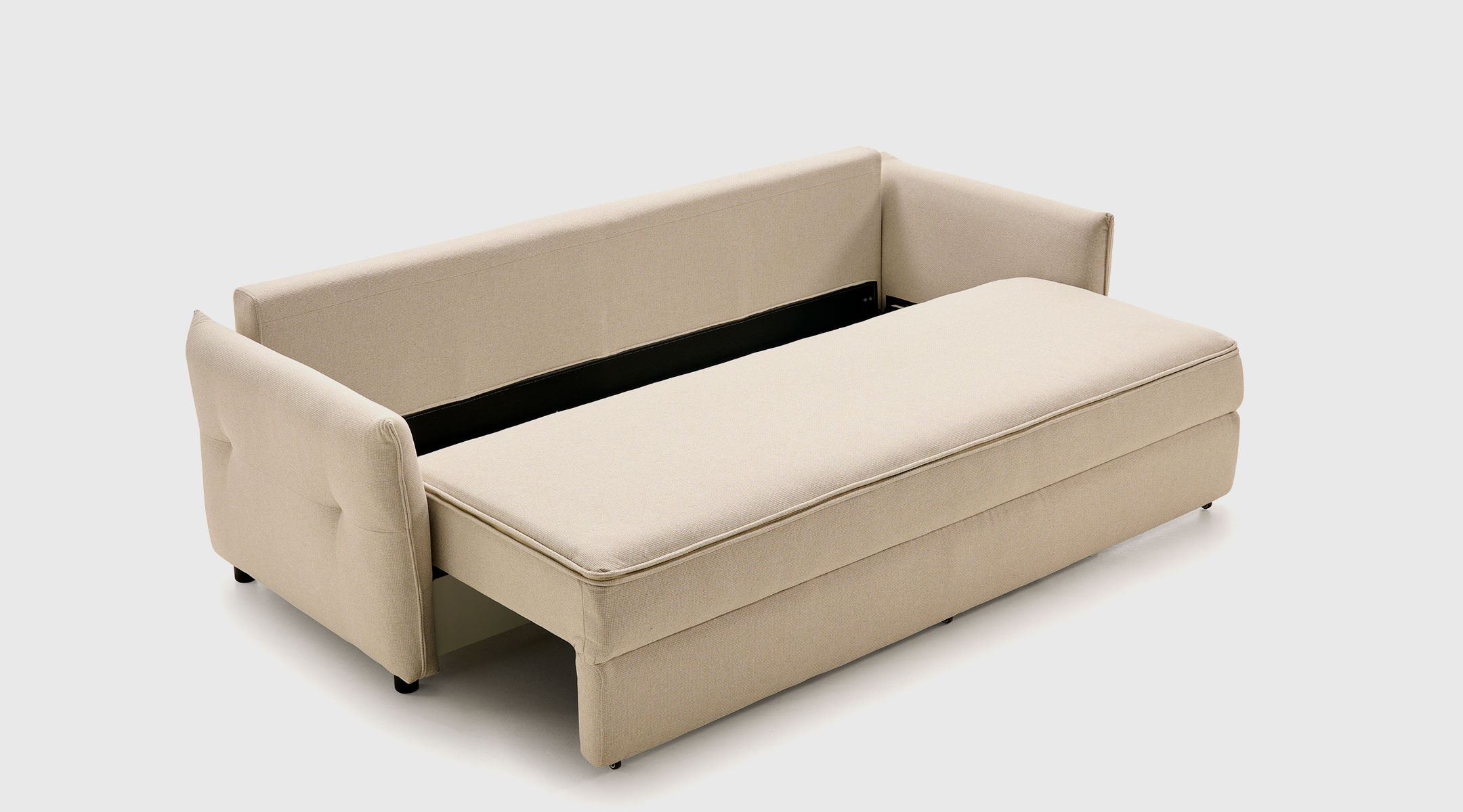 Sofá cama Saori abierto con mecanismo transversal y detalle de arcón de almacenamiento bajo el asiento.