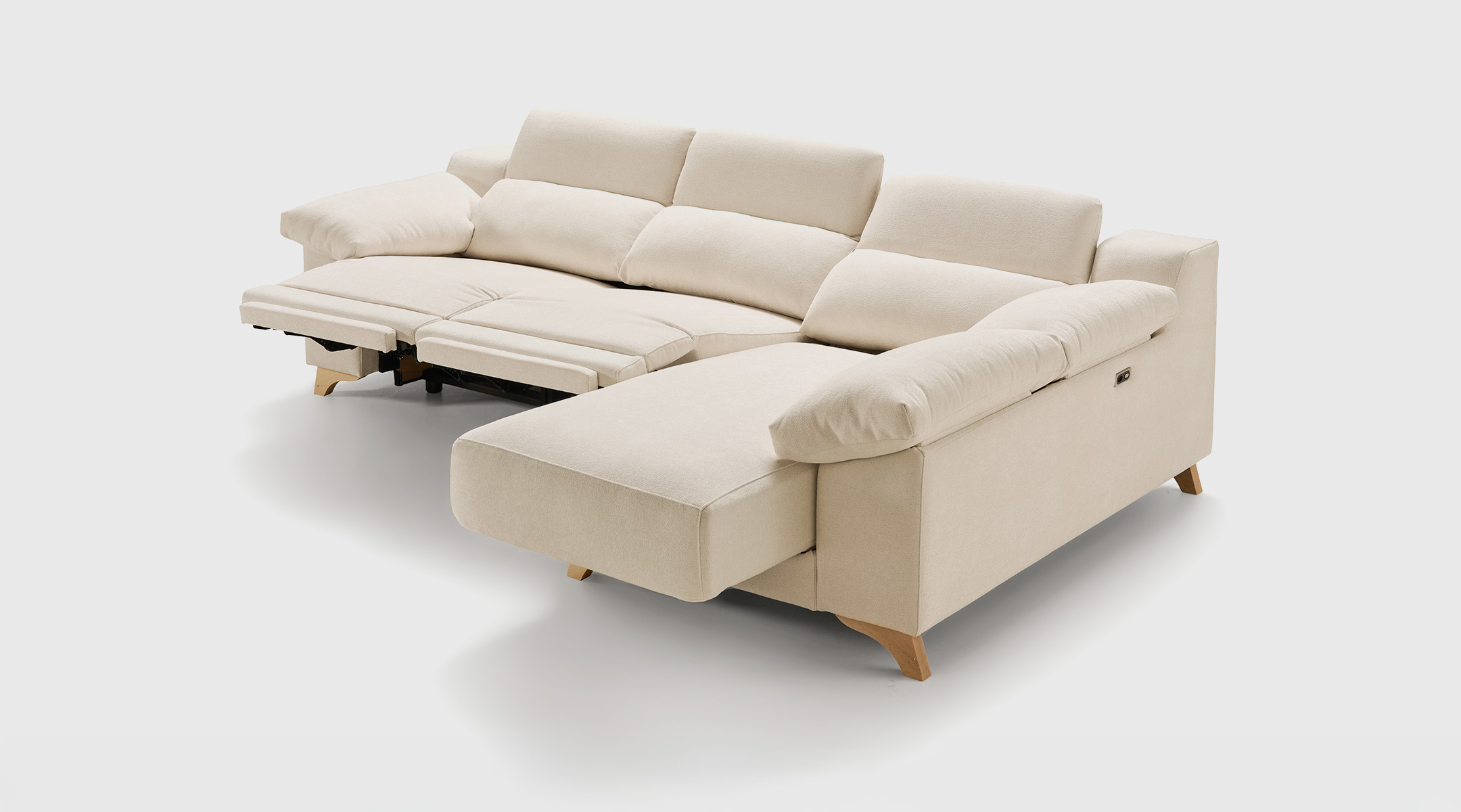 Sofá Chaise Longue Sienna Izquierda - Confort Envolvente Sofá chaise longue Sienna con asientos deslizantes al suelo, respaldos de doble altura y cabezales reclinables, posición izquierda.