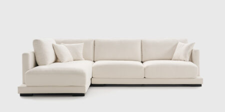 Sofá rinconera Giorno derecha tapizado en tela Hari color blanco, con diseño envolvente y cojines decorativos