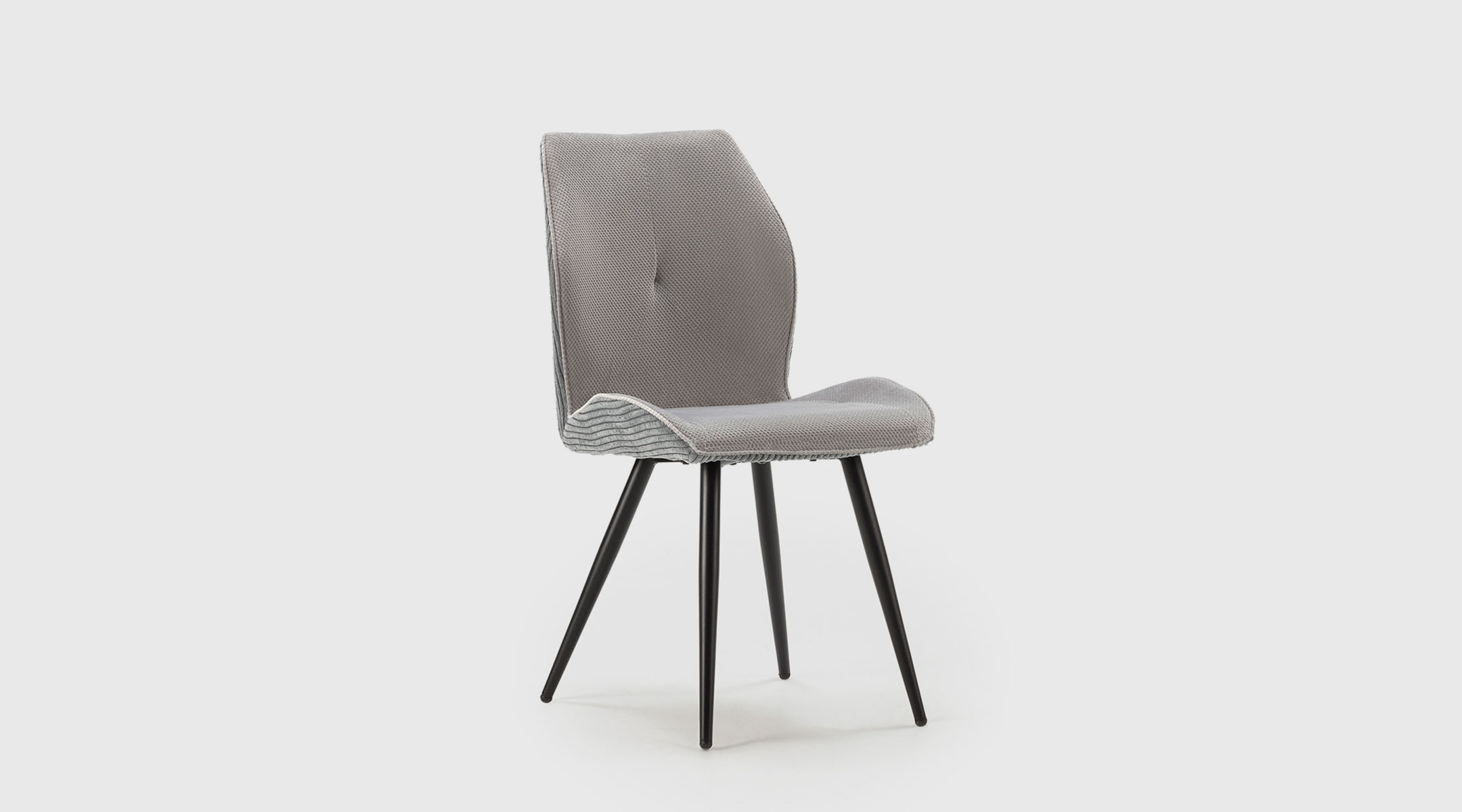 Silla Hera de Mimma Gallery con respaldo envolvente, tapizado suave y patas metálicas negras, disponible en gris claro