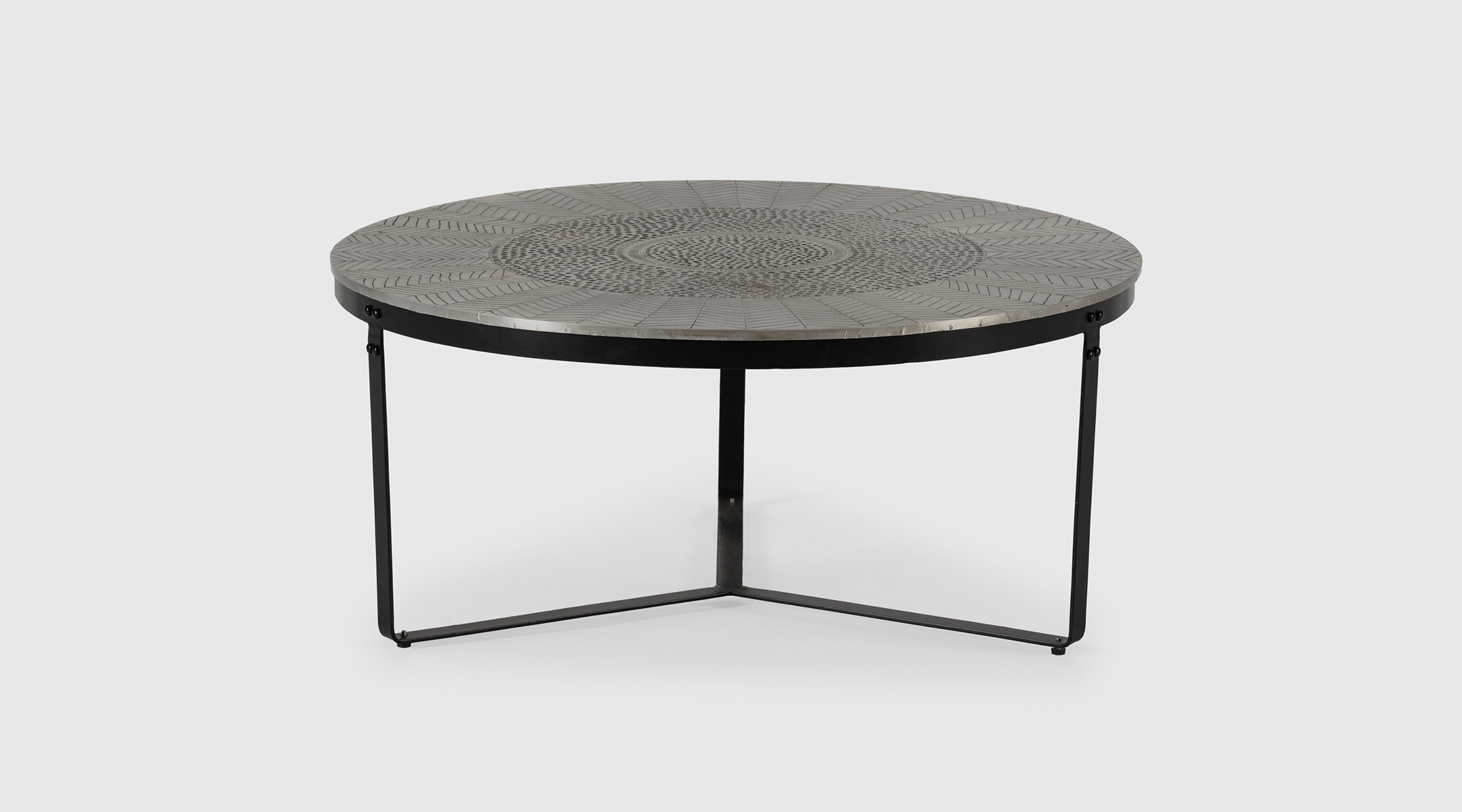 Mesa de centro redonda Brass de Mimma Gallery con sobre de latón envejecido y patas metálicas negras.